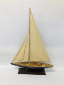 A MODEL WOODEN SAILING BOAT FITTED ON PRESENTATION BASE - LENGTH 60CM. HEIGHT 86CM. WIDTH 12CM.