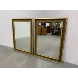 A PAIR OF ORNATE GILT FRAMED BEVELLED WALL MIRRORS EACH W 66CM. H 91CM.