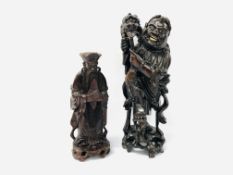 TWO JAPANESE HARDWOOD CARVINGS - A LAUGHING MAN HOLDING A DOG - H 35CM AND A STANDING SAGE - H 26CM.