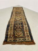 CAUCASIAN RUNNER, THE CENTRAL HOOKED MOTIFS ON A BROWN FIELD, VERY WORN - 343CM X 90CM.