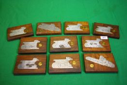 A COLLECTION OF 10 STEEL ENGRAVED SHOT GUN SIDE PLATES MOUNTED IN MAHOGANY,