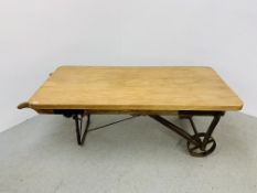 A CONVERTED ANTIQUE SACK BARROW COFFEE TABLE WITH HEAVY WAXED PINE TOP