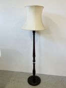 A REPRODUCTION TURNED WOODEN LAMP STANDARD WITH CREAM SHADE