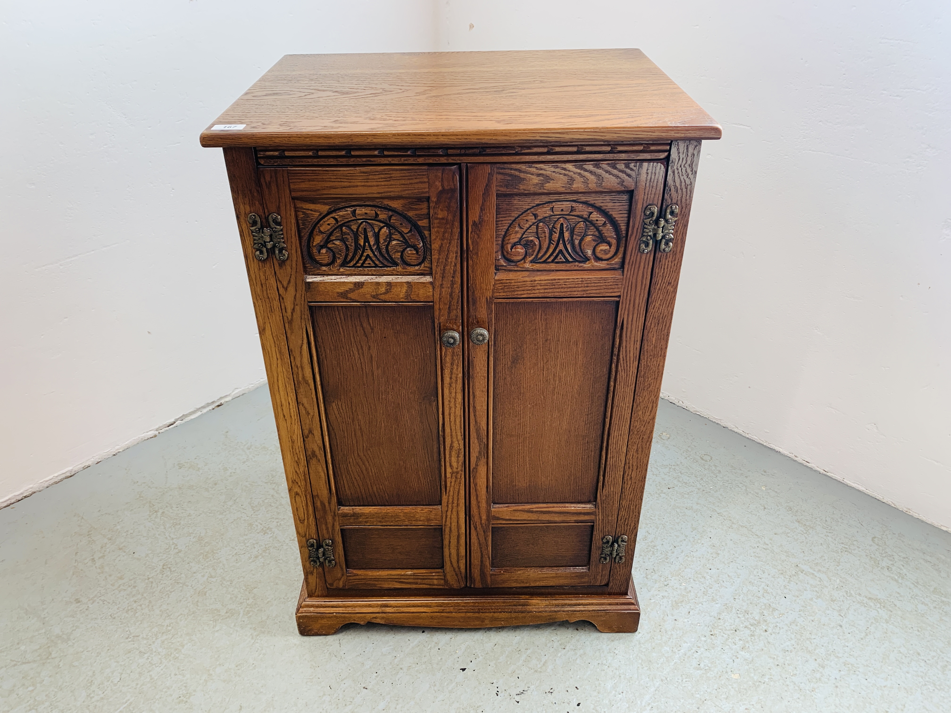 AN OLD CHARM STYLE TWO DOOR CABINET WITH SHELVED INTERIOR AND HINGED TOP - W 62CM. D 49CM. H 94CM.