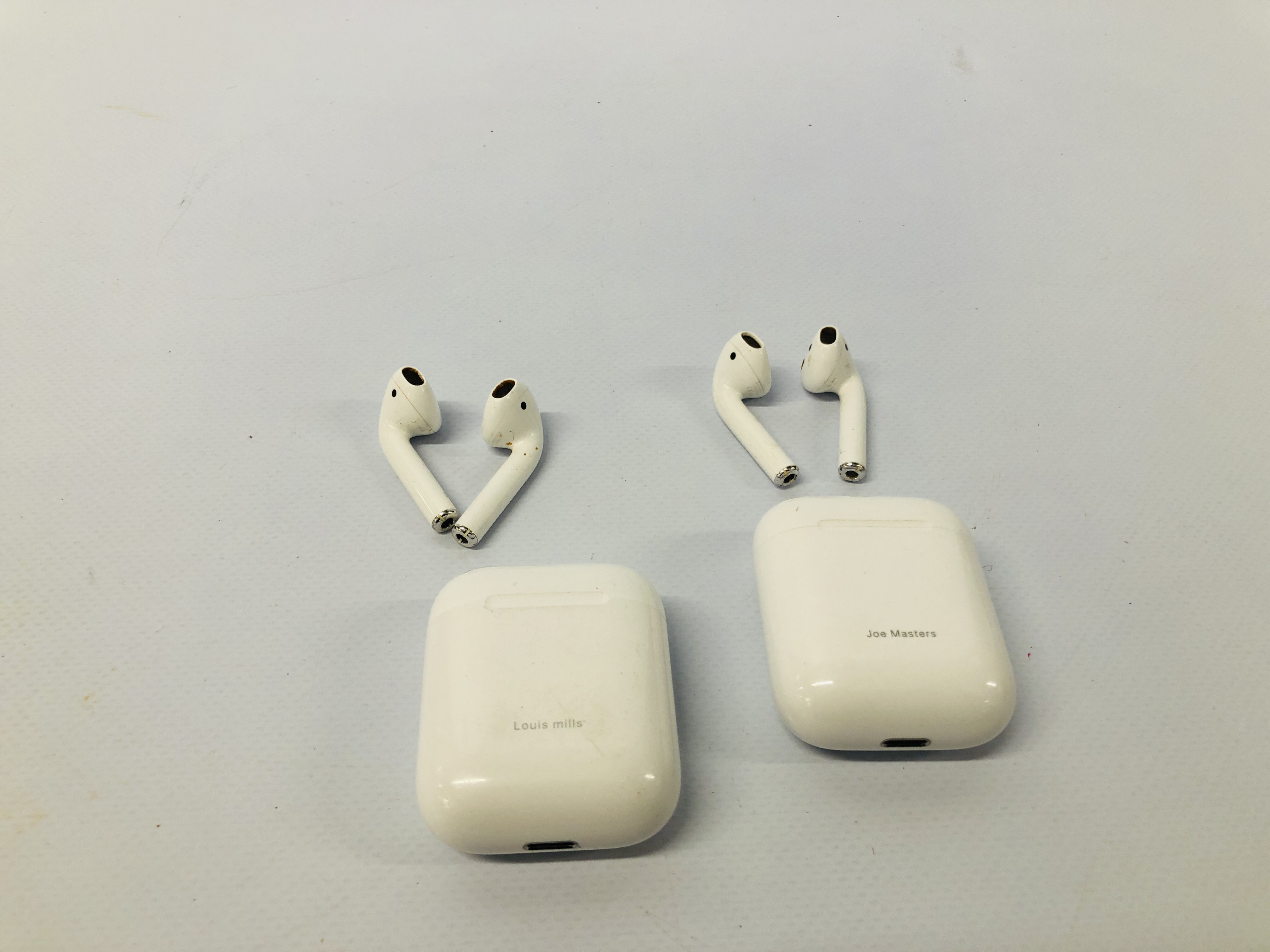 TWO PAIRS OF APPLE EAR PODS WITH CHARGING CASES - NO GUARANTEE OF CONNECTIVITY. SOLD AS SEEN.