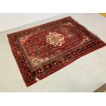 AN EASTERN RED PATTERNED RUG 205CM. X 150CM.