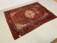 AN EASTERN RED PATTERNED RUG 205CM. X 150CM.