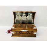 VINTAGE OAK CASED GAMES TANTALUS WITH THREE DECANTERS AND SIX GLASSES AND KEY.