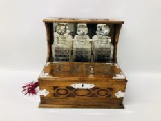 VINTAGE OAK CASED GAMES TANTALUS WITH THREE DECANTERS AND SIX GLASSES AND KEY.