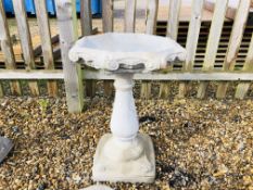 A CLASSICAL STONEWORK BIRD BATH WITH BALUSTER SUPPORT AND SCROLLED DETAIL - HEIGHT 70CM.