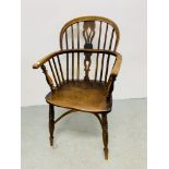 AN ANTIQUE ELM WOOD SEATED STICK BACK ELBOW CHAIR.