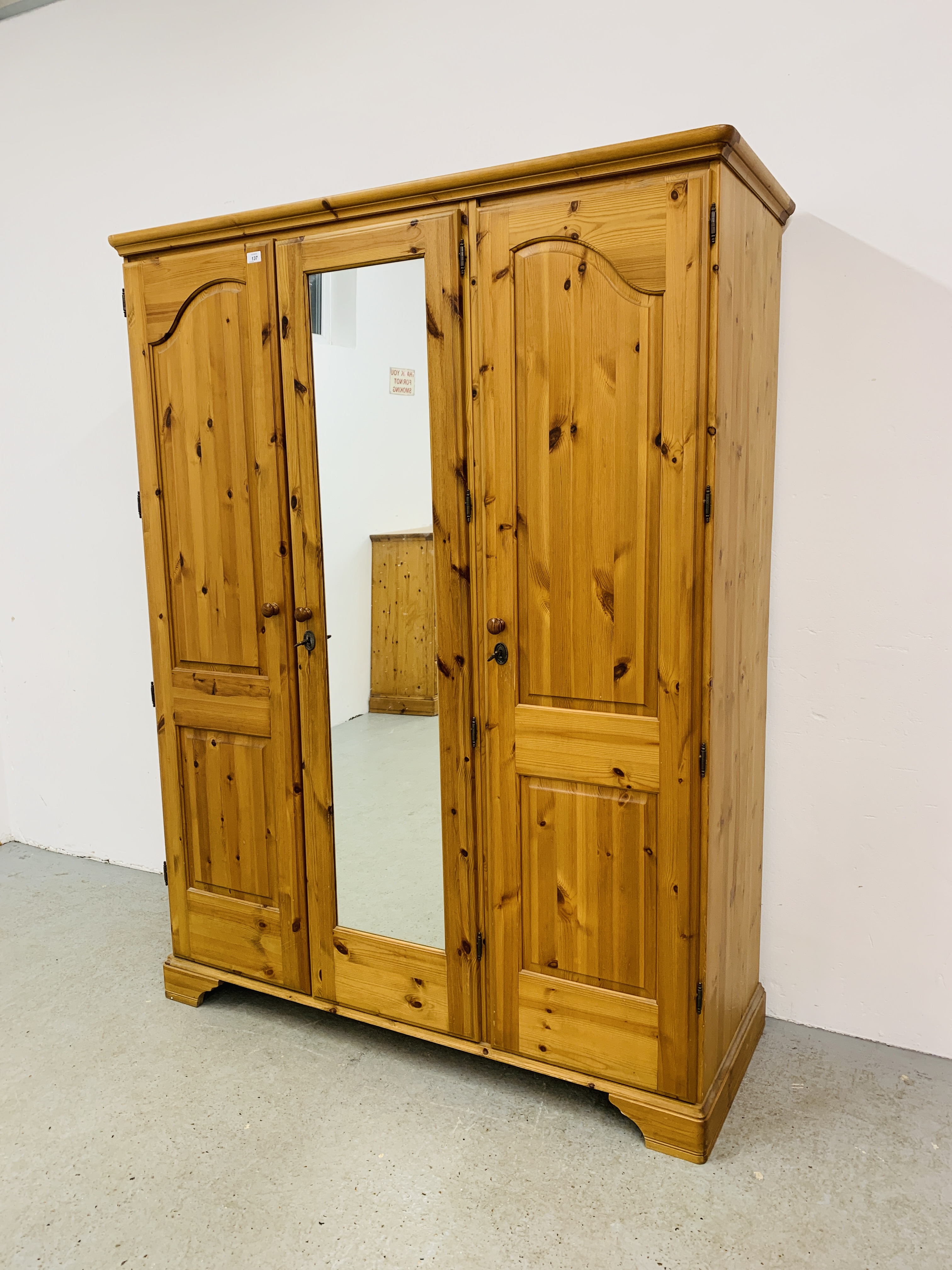 A GOOD QUALITY MODERN HONEY PINE TRIPLE WARDROBE WITH CENTRAL MIRRORED DRAWER MANUFACTURED BY