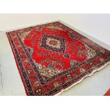 LARGE RUG ON A MAINLY RED BACKGROUND 300 X 390CM.