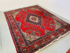 LARGE RUG ON A MAINLY RED BACKGROUND 300 X 390CM.