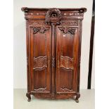 A LARGE REPRODUCTION MAHOGANY FINISH WARDROBE WITH DECORATIVE CARVED DETAIL HEIGHT 215CM.