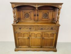 A REPRODUCTION OAK FINISH COURT CUPBOARD WITH CARVED DETAILING W 125CM, D 48CM, H 135CM.