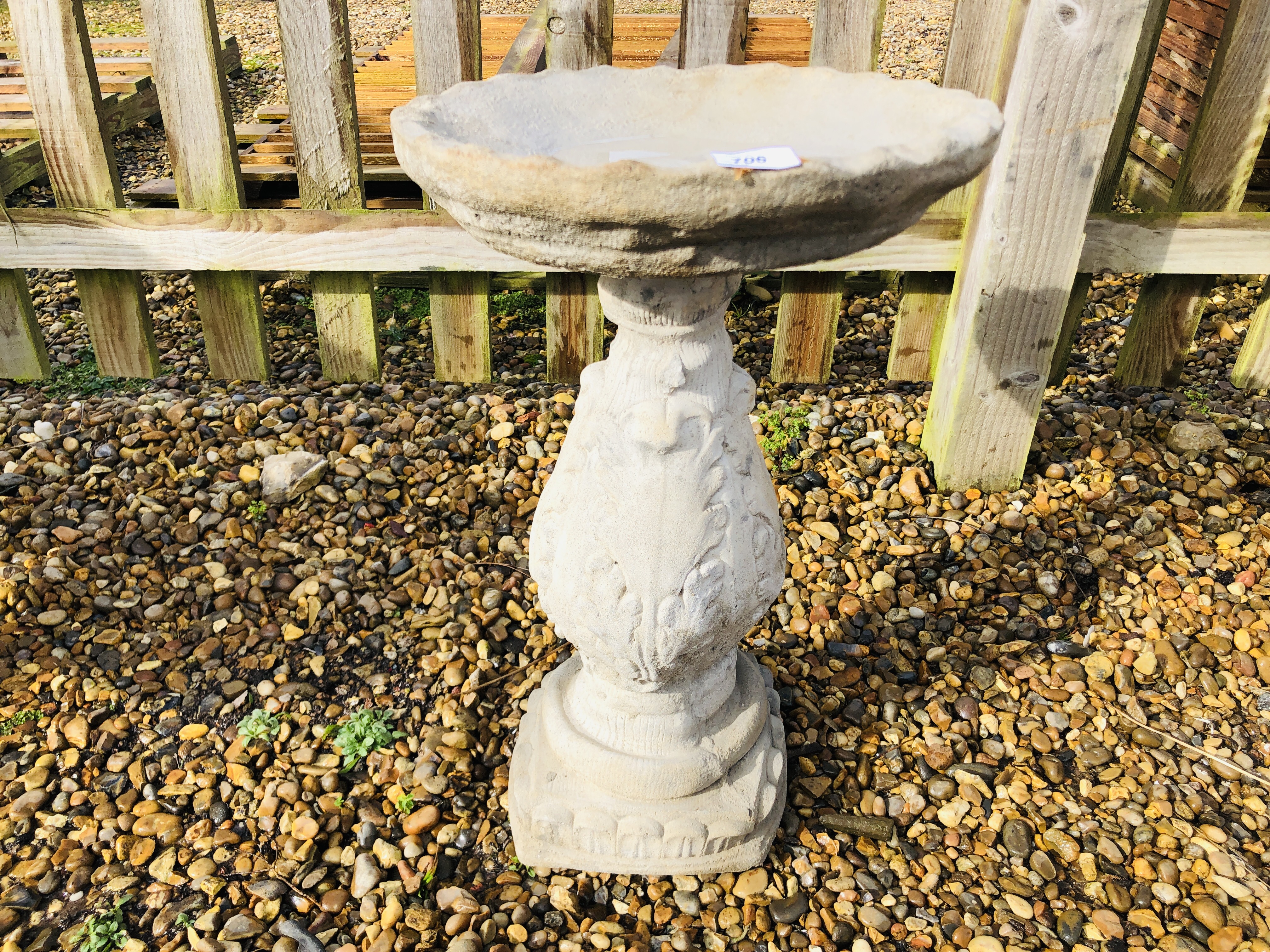 A STONEWORK BIRD BATH, THE BALUSTER SUPPORT WITH FOLIAGE DESIGN - HEIGHT 60CM.