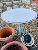 A CIRCULAR TOP TABLE WITH DECORATIVE CAST METAL BASE.
