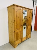 A GOOD QUALITY MODERN HONEY PINE TRIPLE WARDROBE WITH CENTRAL MIRRORED DRAWER MANUFACTURED BY