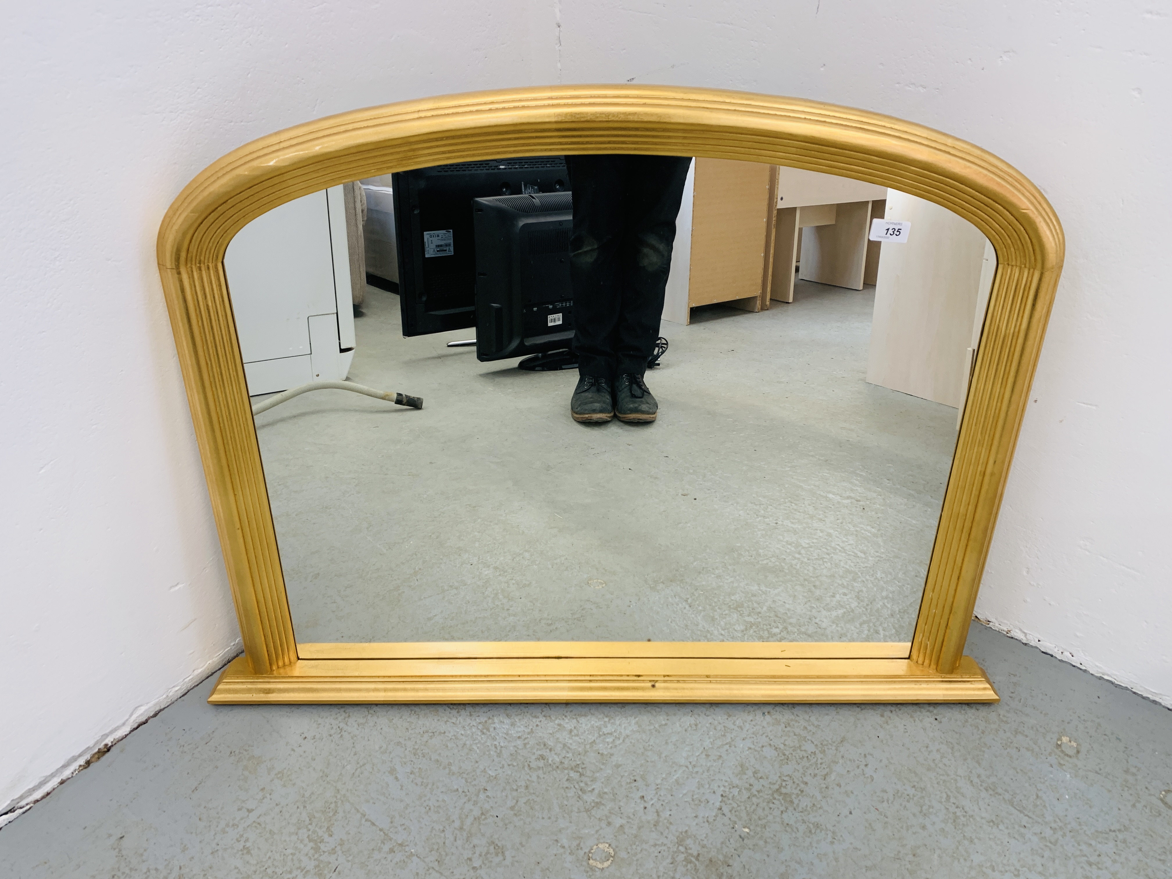 A REPRODUCTION GILT FINISH ARCHED OVERMANTLE MIRROR WIDTH 101CM. HEIGHT 74CM.