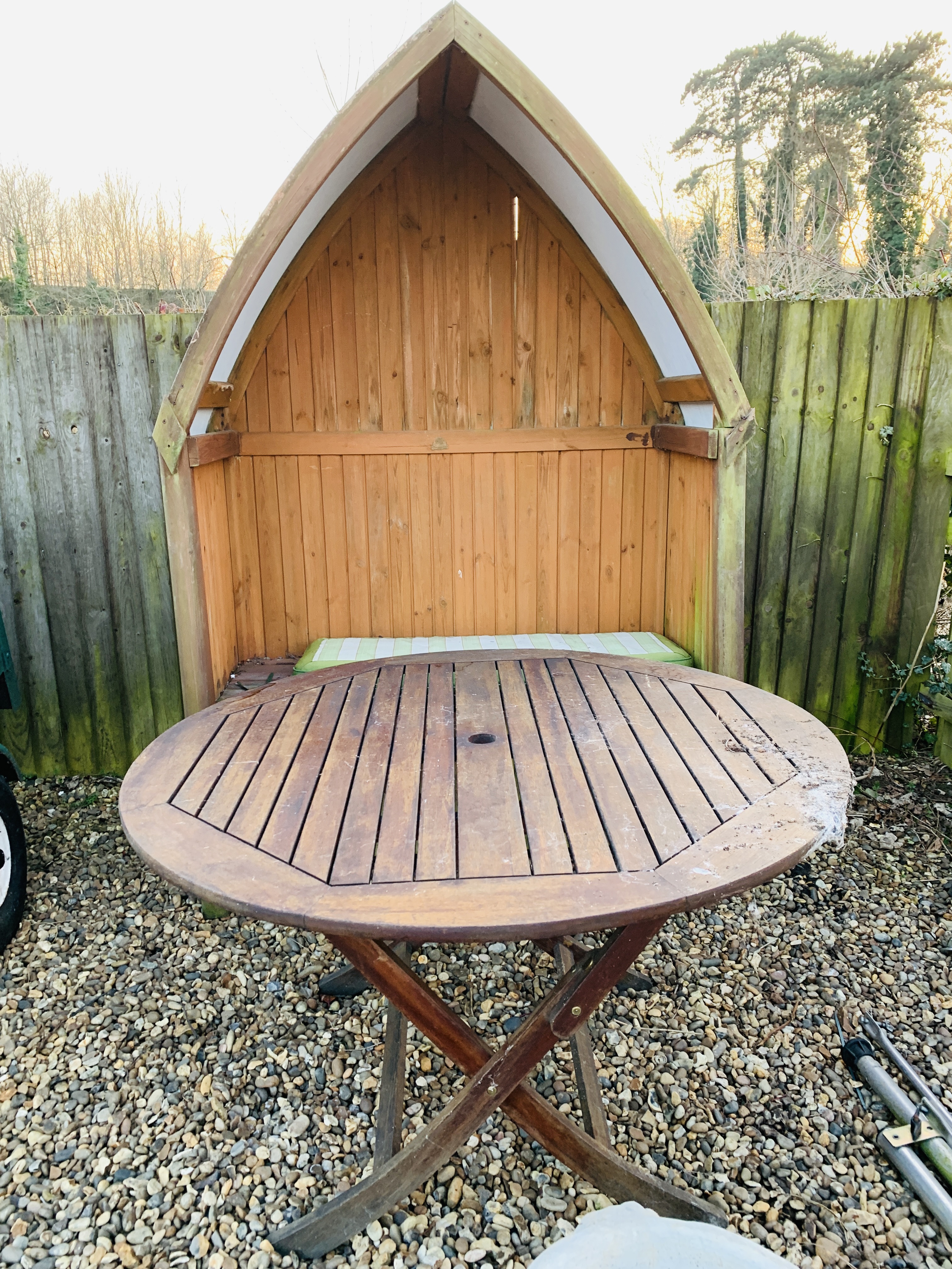 A TWO SEAT GARDEN LOVE ARBOUR AND FOLDING HARDWOOD GARDEN TABLE