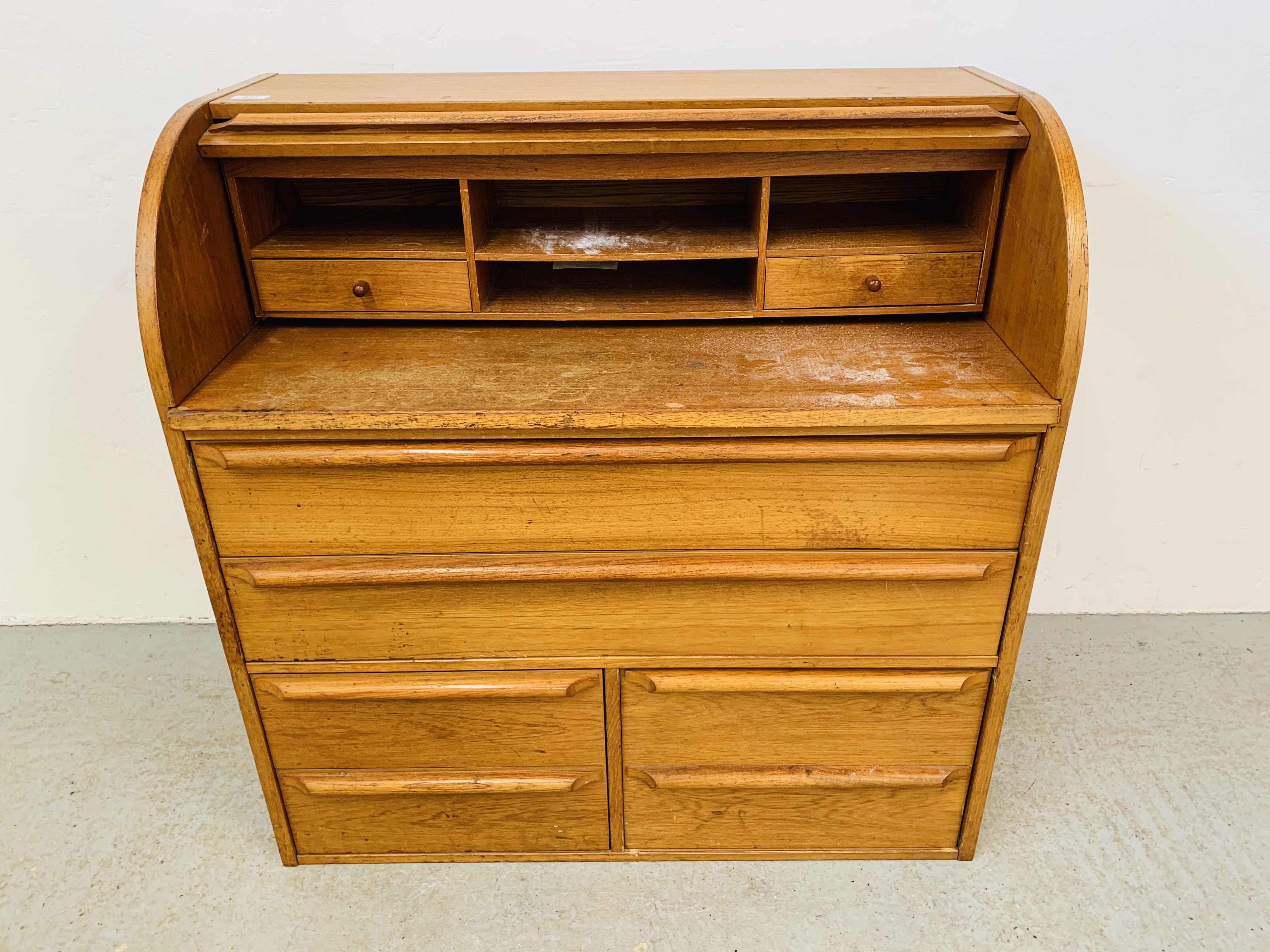 A TEAK FINISH MID CENTURY CYLINDER TOP BUREAU DESK WITH SLIDING WRITING SURFACE