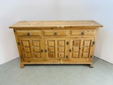 A THREE DRAWER THREE DOOR PINE SIDEBOARD WITH DECORATIVE PANEL DETAIL