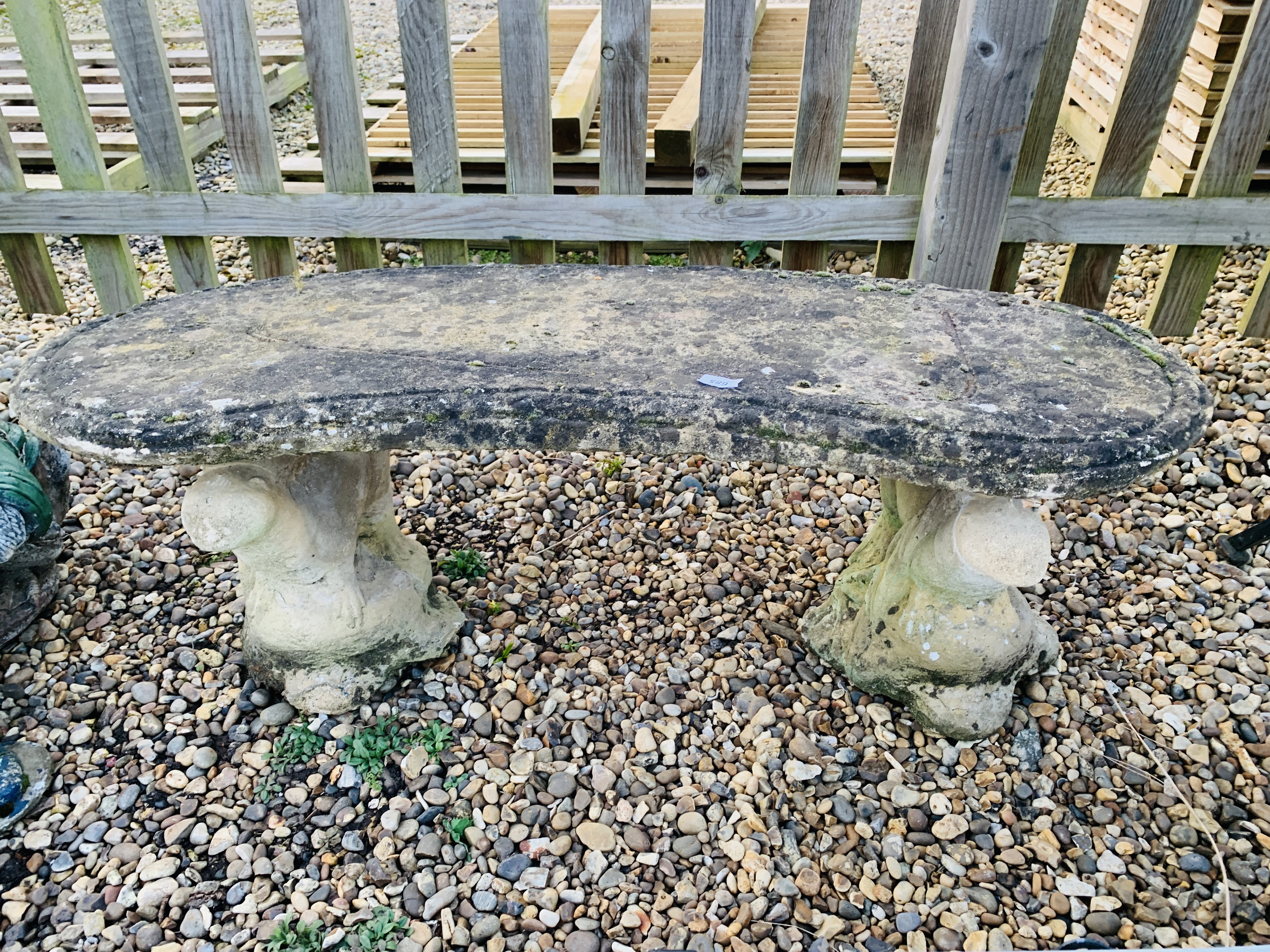 A CONCRETE GARDEN BENCH WITH OTTER DETAIL