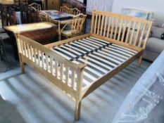 A SOLID BEECHWOOD DOUBLE BEDSTEAD (REPLACEMENT BOLTS REQUIRED)