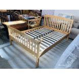 A SOLID BEECHWOOD DOUBLE BEDSTEAD (REPLACEMENT BOLTS REQUIRED)