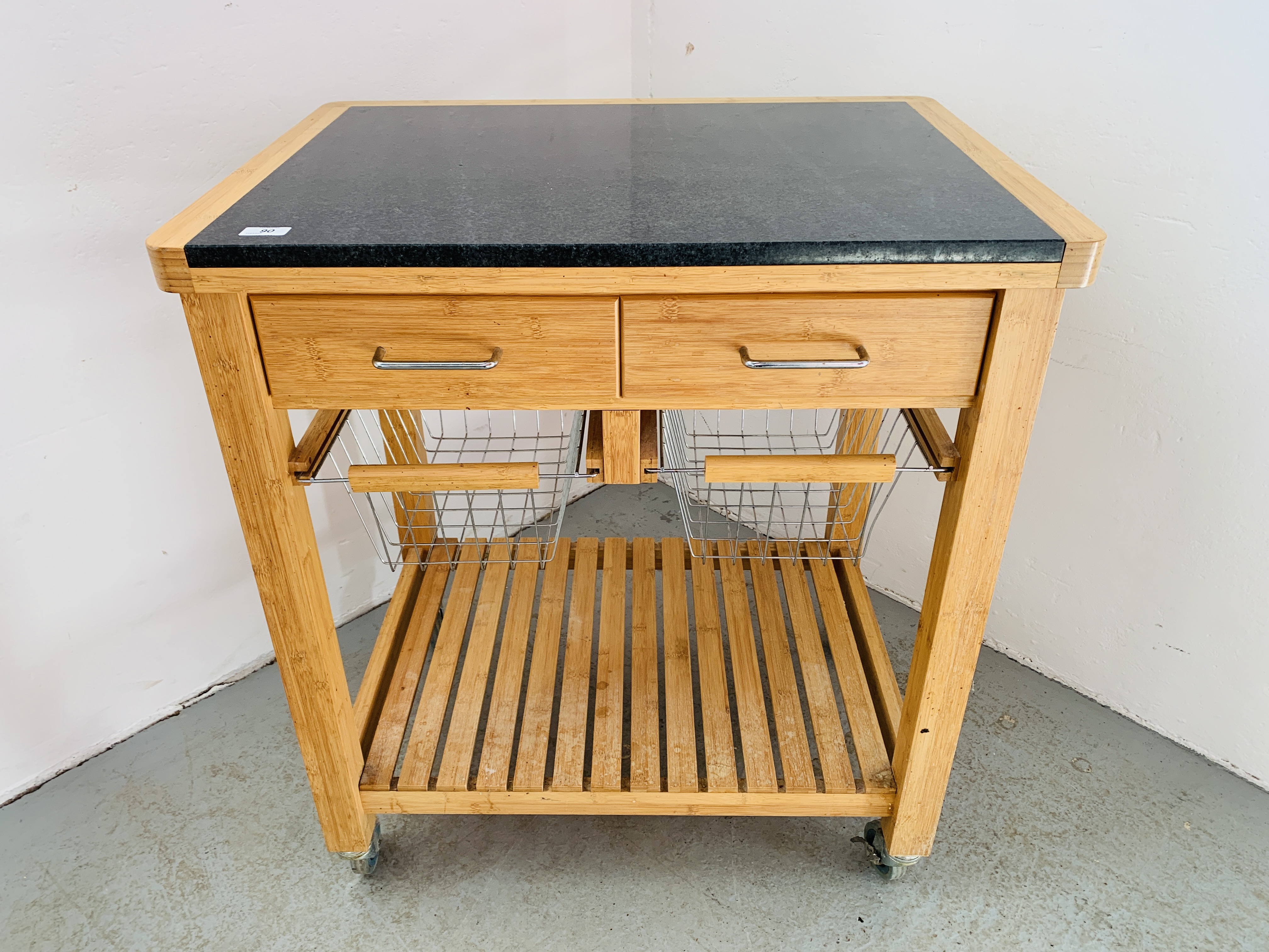 A TWO DRAWER KITCHEN WORKSTATION WITH SOLID GRANITE PREPARATION TOP, WHEELED.