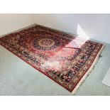 A LARGE RED PATTERNED EASTERN CARPET 316 X 208CM.