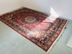 A LARGE RED PATTERNED EASTERN CARPET 316 X 208CM.