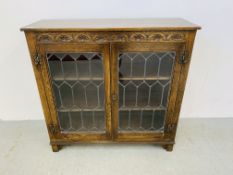 AN OAK OLD CHARM STYLE BOOKCASE WITH LEADED GLASS DOORS.