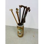 A REPRODUCTION ORIENTAL CERAMIC STICK STAND ALONG WITH 8 VARIOUS WALKING STICKS