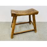 A RUSTIC STOOL WITH SHAPED SEAT.