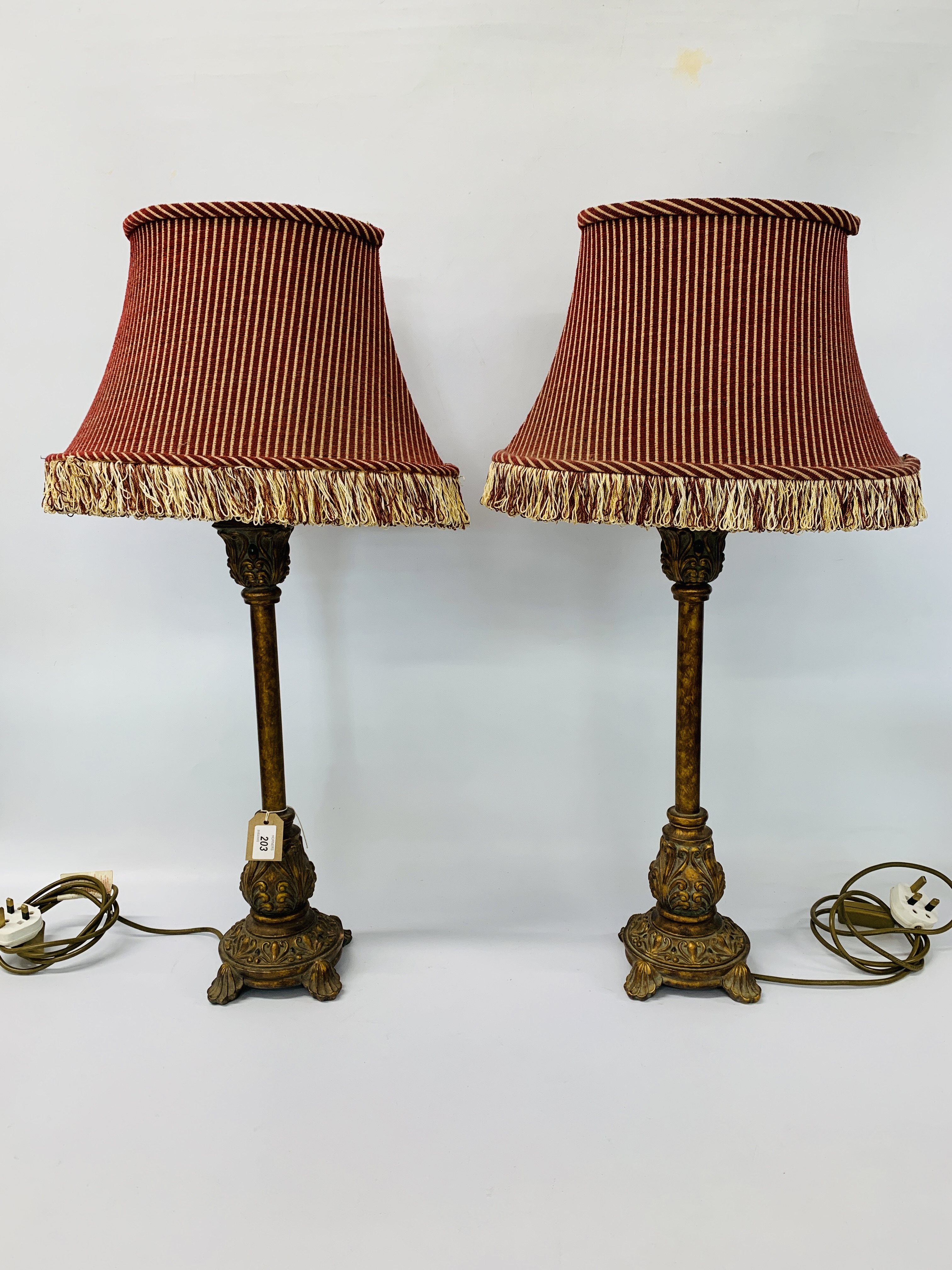 PAIR OF CLASSICAL ANTIQUE EFFECT TABLE LAMPS WITH RED STRIPED FRINGED SHADES HEIGHT 77CM.