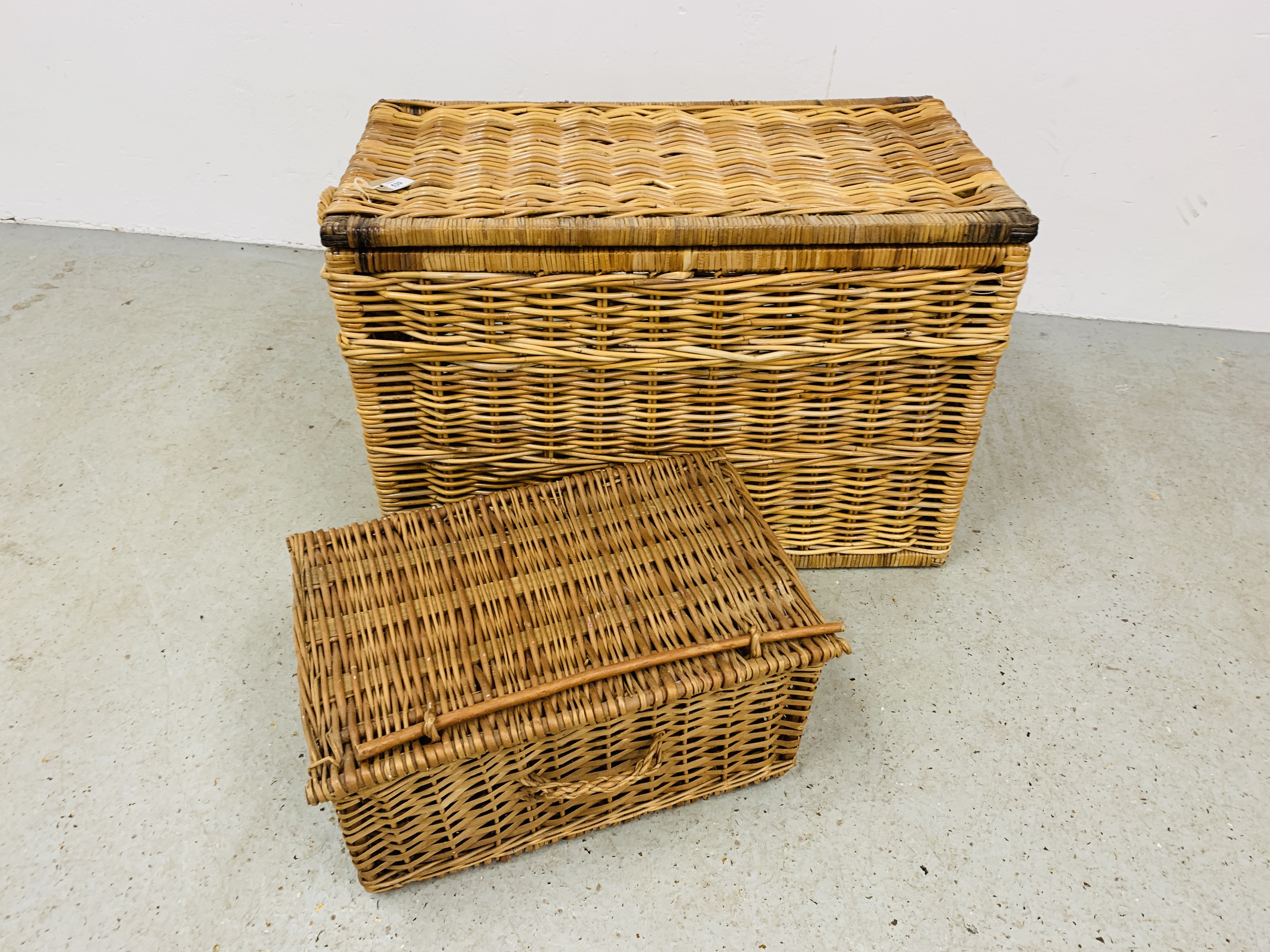 A LARGE WICKER BASKET 81CM. X 44CM. X 55CM.