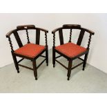 A PAIR OF OAK FRAMED CORNER CHAIRS WITH BARLEY TWIST DETAIL AND RED UPHOLSTERED SEAT