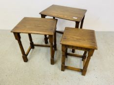 A GRADUATED NEST OF THREE OAK OCCASIONAL TABLES.