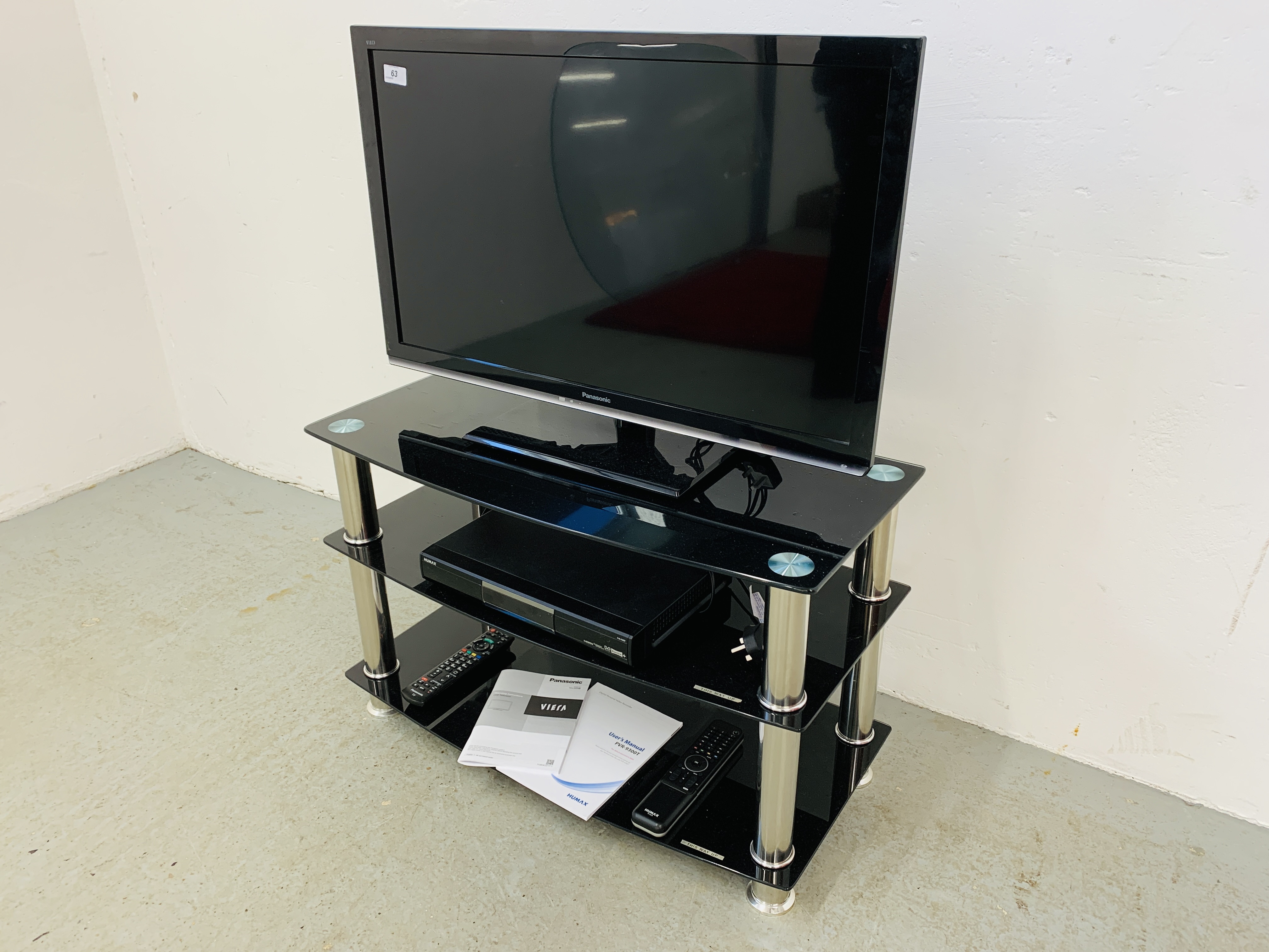 A PANASONIC VIERA 32 INCH TELEVISION WITH REMOTE ON GLASS THREE TIER STAND + HUMAX HD RECORDER WITH