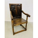 AN ANTIQUE OAK ARMCHAIR WITH TURNED SUPPORTS AND PANELLED BACK