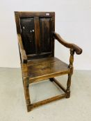 AN ANTIQUE OAK ARMCHAIR WITH TURNED SUPPORTS AND PANELLED BACK