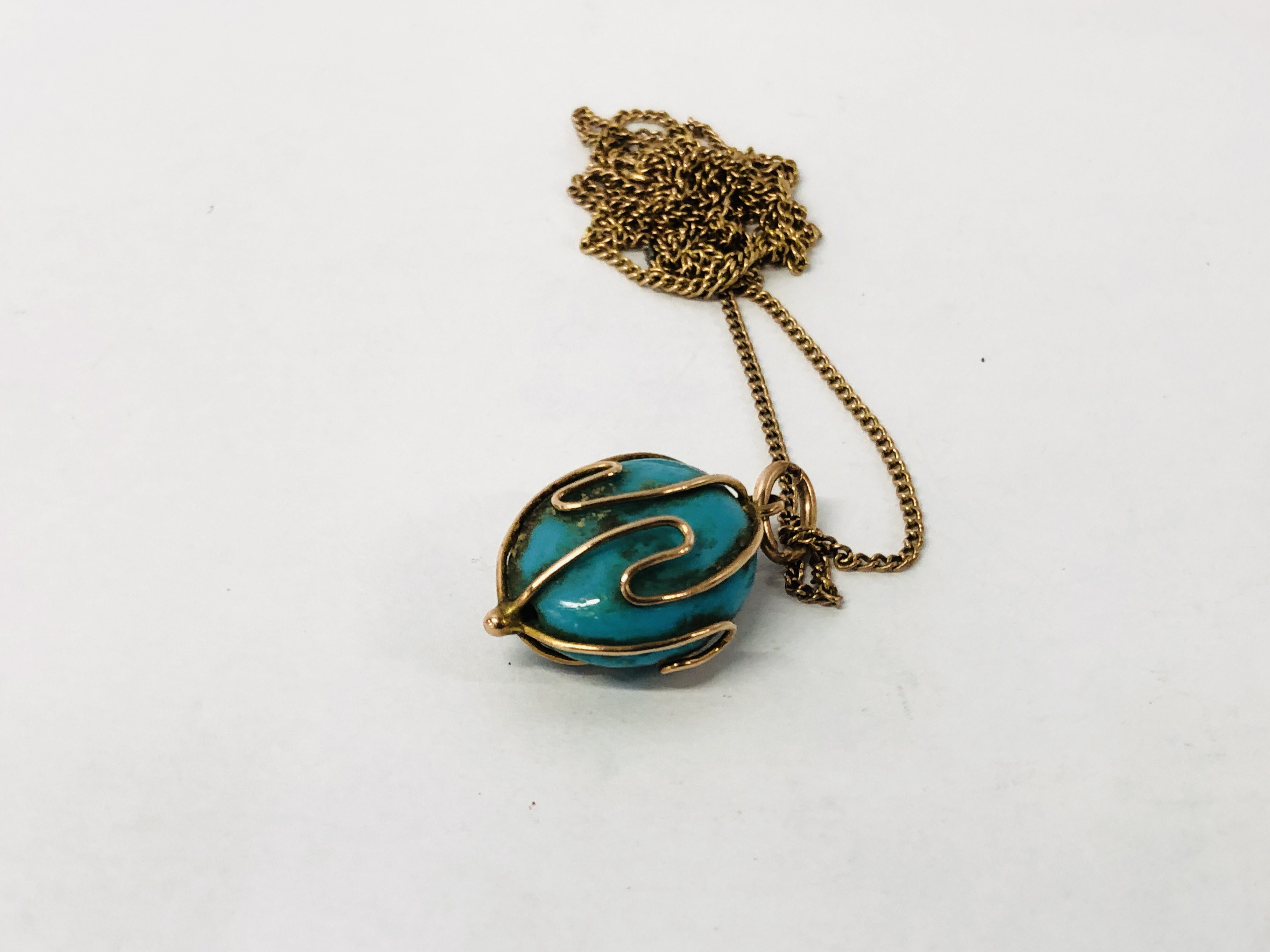 A 9CT GOLD CHAIN SUPPORTING AN OVAL BLUE HARD STONE PENDANT. - Image 4 of 7