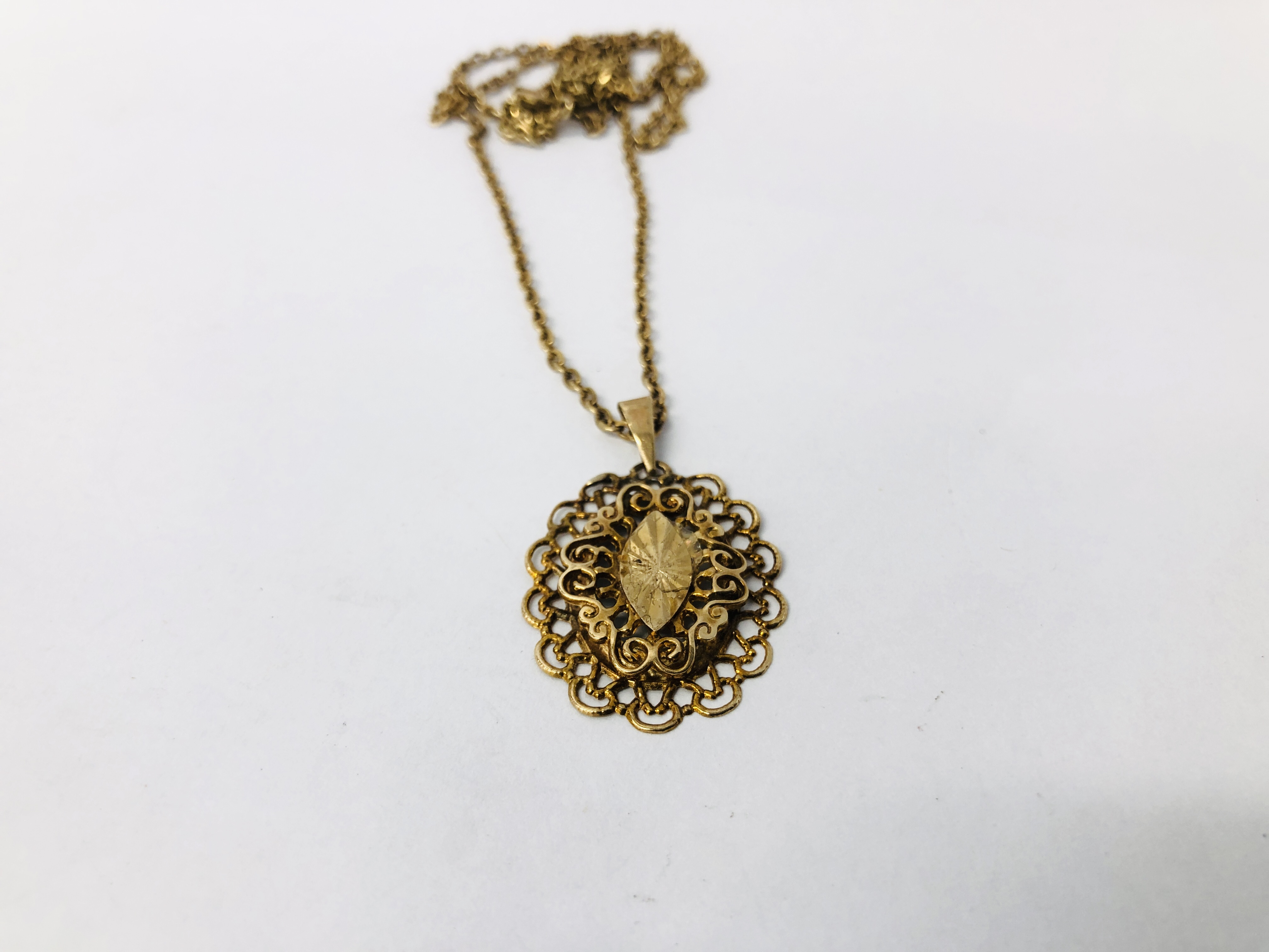 A YELLOW METAL CHAIN WITH AN UNMARKED OVAL PIERCED PENDANT. - Image 2 of 9