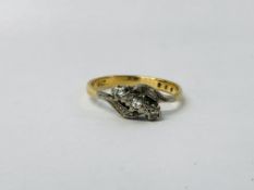 A THREE STONE DIAMOND CROSS OVER RING ON AN 18CT GOLD BAND.