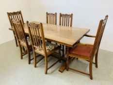 A SOLID OAK REFECTORY DINING TABLE ON TURNED CARVED SUPPORTS AND STRETCHER BASE COMPLETE WITH A SET