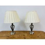 A PAIR OF MODERN DESIGNER OPEN METALCRAFT TABLE LAMPS WITH CREAM PLEATED SHADES - SOLD AS SEEN.