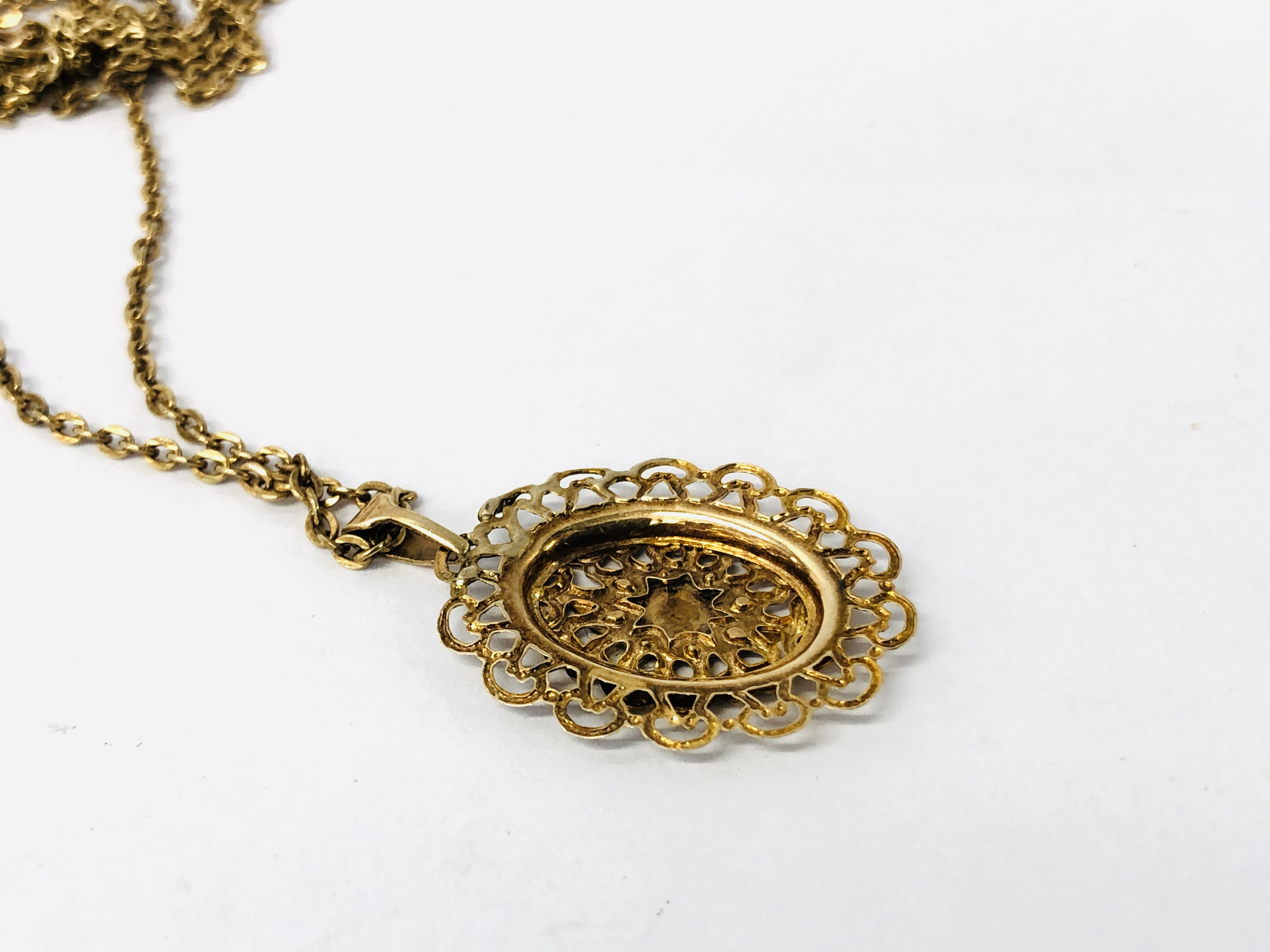 A YELLOW METAL CHAIN WITH AN UNMARKED OVAL PIERCED PENDANT. - Image 3 of 9