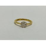 18CT GOLD DIAMOND FLOWER HEAD RING SET WITH 7 SMALL STONES.